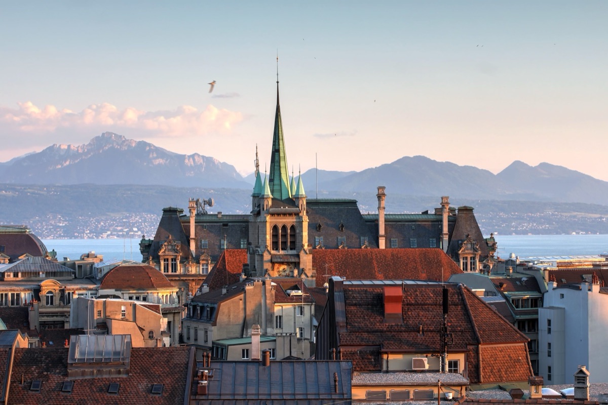 Toits de Lausanne au coucher du soleil, avec le lac Léman et les Alpes en arrière-plan