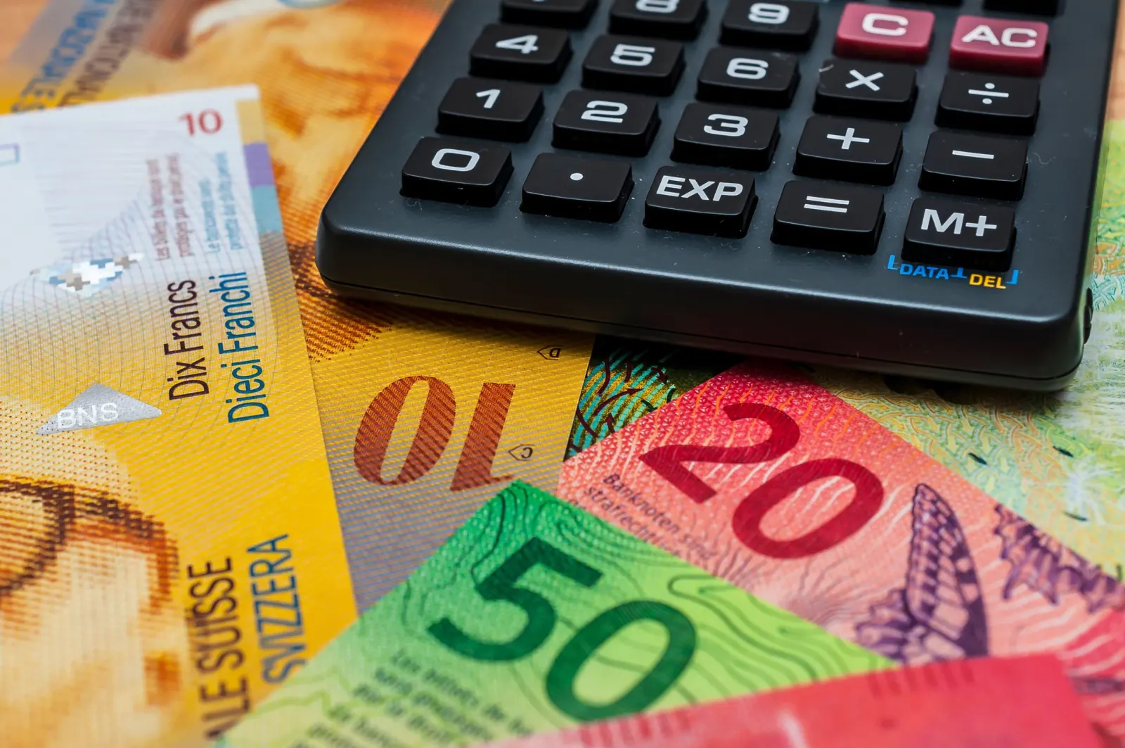 Billets de banque suisses de 10, 20 et 50 francs sous une calculatrice