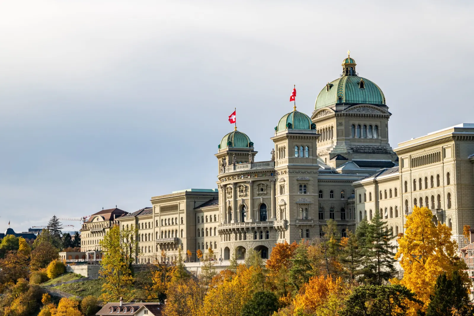 The Federal Palace in Bern, surrounded by trees in autumn colours