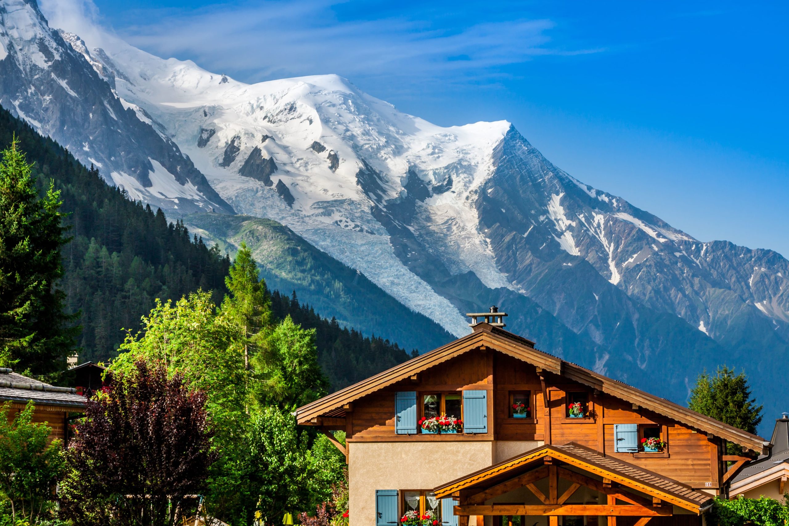 Chalet en bois typique à Chamonix utilisé comme résidence secondaire, avec vue panoramique sur le Mont-Blanc et les Alpes enneigées.