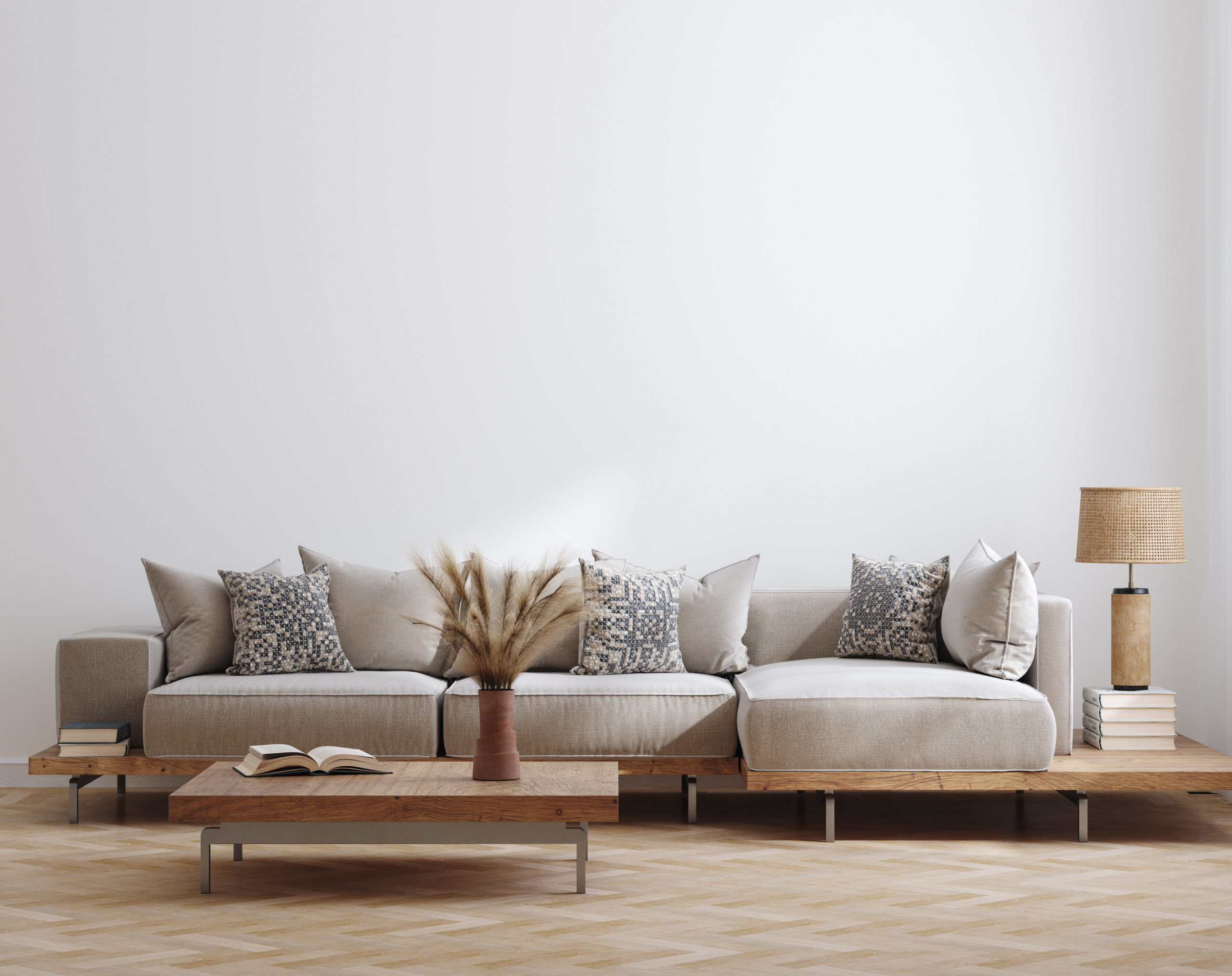 Salon contemporain avec canapé beige, coussins texturés, table basse en bois et lampe en fibres naturelles, dans un intérieur minimaliste aux tons neutres.